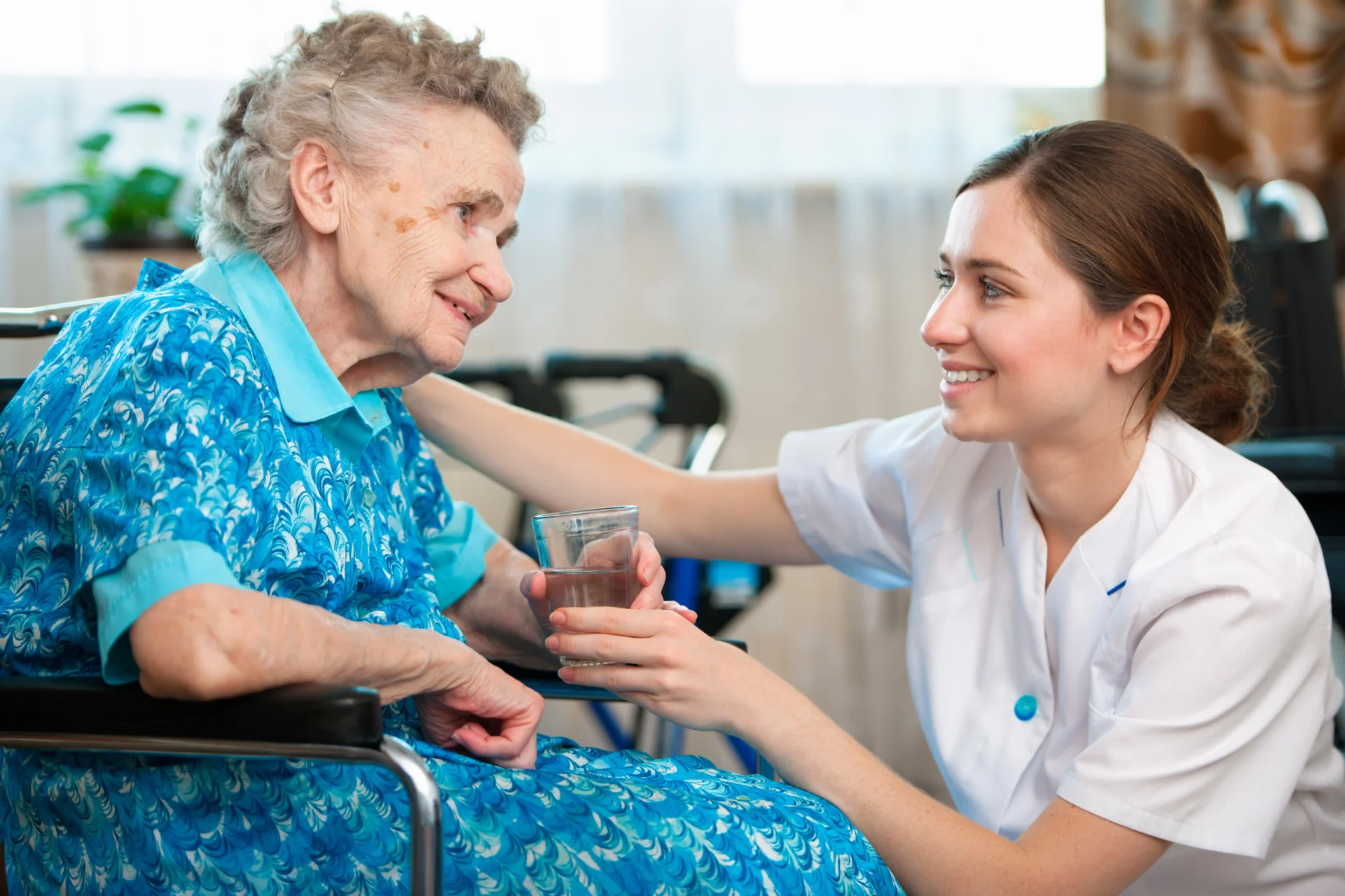 a person in a wheelchair holding a glass of water