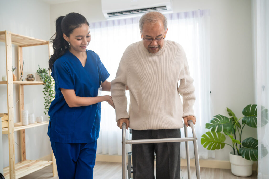 A caregiver with a senior elderly man doing physical therapy for Alzheimer’s