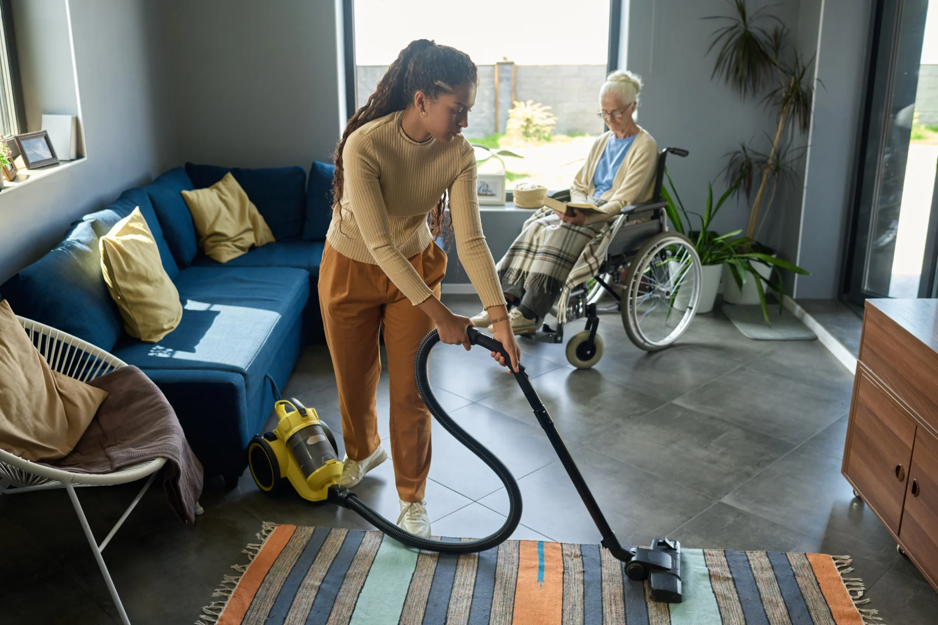 a person vacuuming a rug in a home care
