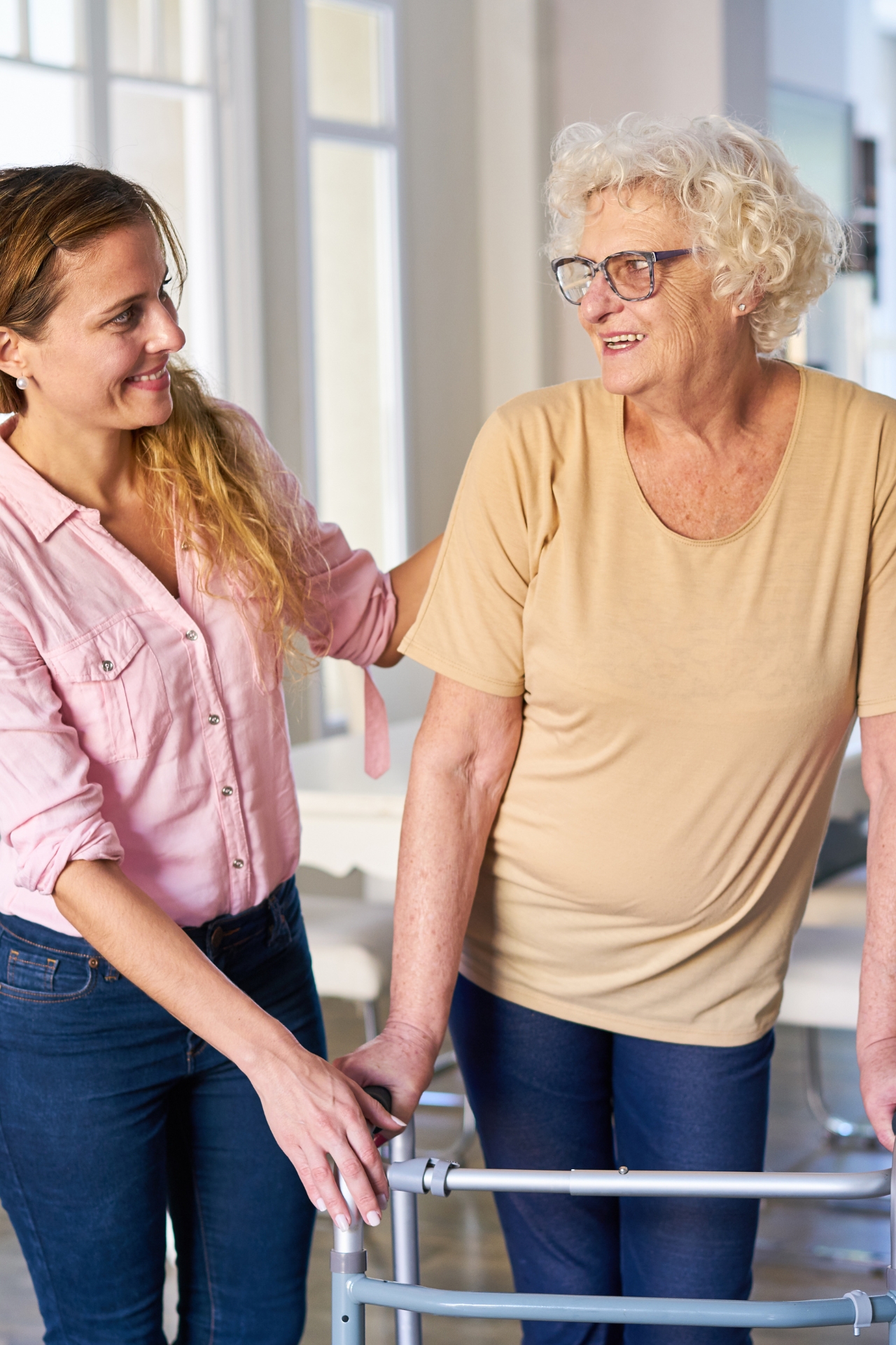 Young woman assisting elderly woman with walker, providing senior care in Chicago area