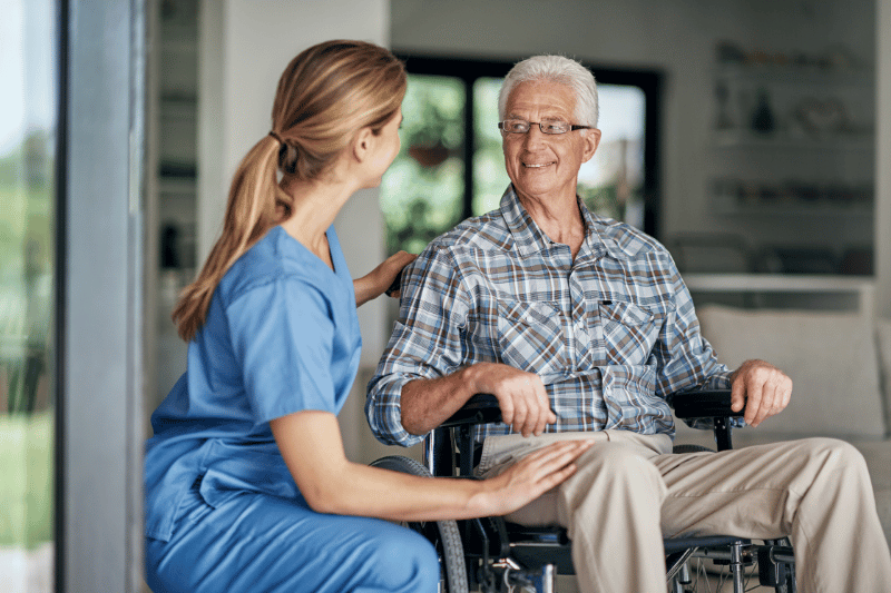 A caretaker provides personalized care in Chicago area to an elderly man in a wheelchair