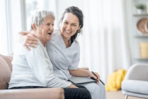 A caregiver and an older woman sit together on a couch, embodying the spirit of respite care in Chicagoland.