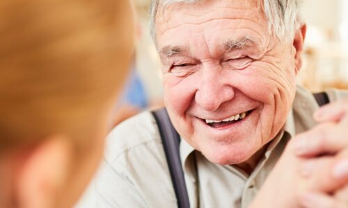 A senior smiling while a caregiver is providing mobile care Chicago area services